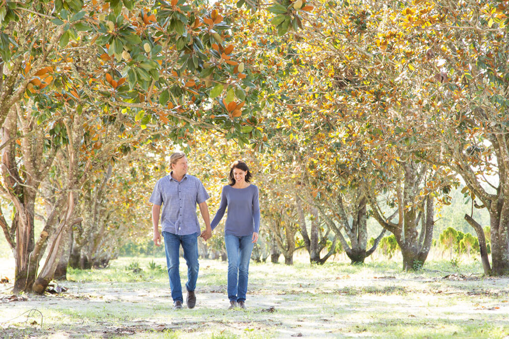 Matt & Julie Walking hand in hand through the Magnolia Grove